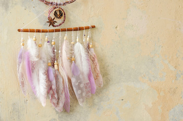 Closeup details modern dreamcatcher with gemstones, crochet doily snowflake, painted feathers,...