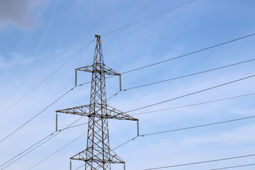 High voltage power line support with electrical wires on blue sky with clouds. Electricity transmission lines, power supply concept