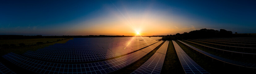 Aerial of a solar farm panoramic at sunrise in the English countryside