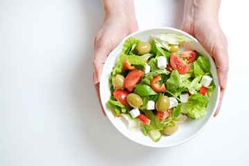 Traditional greek salad with fresh ingredients, feta cheese, olives, red tomatoes, cucumbers and...