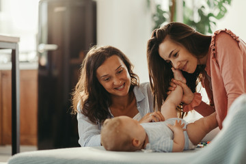 Affectionate women enjoying in time with a baby son at home. - obrazy, fototapety, plakaty