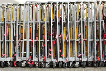 Warehouse trolleys folded and stored in a line with securing straps