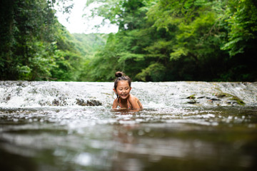 Fototapeta na wymiar 川で遊ぶ女の子
