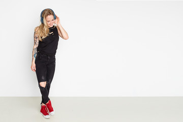 Young women listening to music with bluetooth headphones on a white background with copy space