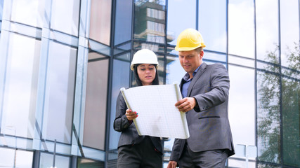 Team of architects and engineer in group on construciton site check documents and business workflow. Engineer inspection in workplace for architectural plan. Concept of: Woman, Man, Suite, Business.