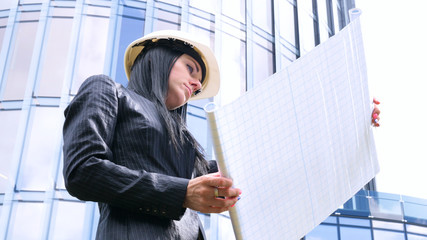 Female contractor in helmet with folder. Building, developing, construction and architecture. Concept of: Woman, Business, Skyscraper, Business plan, Work, Lifestyle, Beautiful.