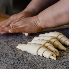 Finished production raw croissants in factory in the steel table. Production of bread, closeup. Working process. Private bakery. Production of bread.