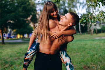 Fototapeta premium Couple man and woman have a fun time outdoor. Girl hugging a guy behind