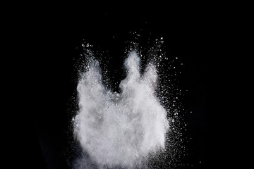Freeze motion of white color powder exploding on dark background. 