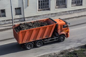Dump Truck Transports Land in a backyard along a street