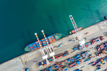 Aerial view. Container ship in pier with crane bridge carries out export and import business in the open sea. Logistics and transportation