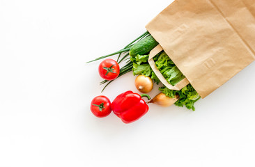 Healthy food with fresh vegetables in paper bag on white background top view space for text