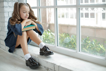 Girl schoolgirl reads a book. School fashion. Fashionable school uniform. - obrazy, fototapety, plakaty