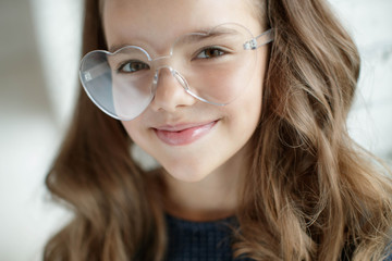 Child girl wears glasses. Optics. 