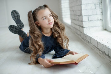 Teen girl reading a book. School fashion. 