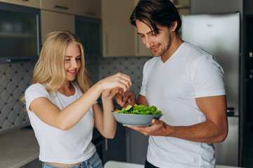 Closeup portrait of couple in the kitchen cooking healthy food .