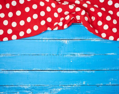 red textile towel with white circles on a blue wooden background