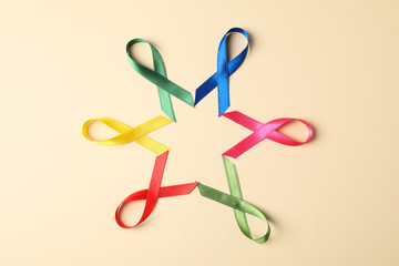 Flat lay composition with awareness ribbons on color background, space for text.