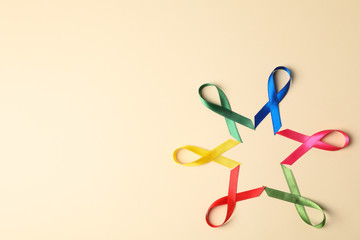 Flat lay composition with awareness ribbons on color background, space for text.