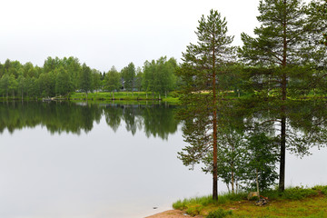 Northern landscape with forest lake in rainy weather. Ruka, Finland