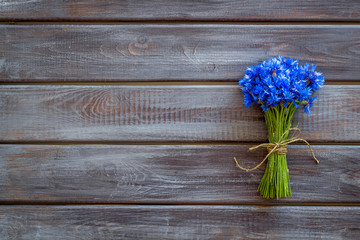 Field flowers design with bouquet of blue cornflowers on wooden background top view space for text