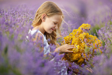 A child in a field with flowers. Teen girl in a lavender field. Happy child in nature. 