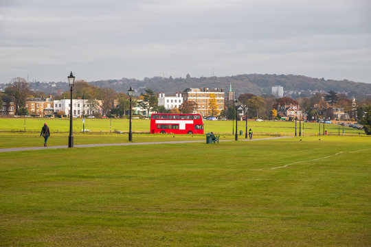 A red London bus driving through the Blackheath