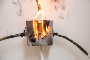Electrical short circuit. Wiring cable on fire flame