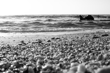Black and white summer background of hot sand with sea or ocean wave bubbles with copy space for card or advertisement at dawn or sunset