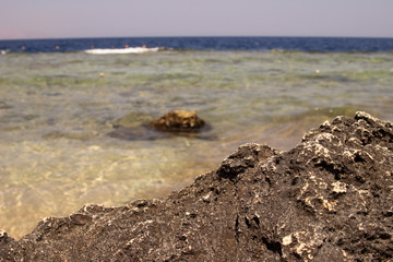 Summer background of hot sand with sea or ocean wave bubbles with copy space for card or advertisement at dawn or sunset