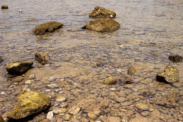 Summer background of hot sand with sea or ocean wave bubbles with copy space for card or advertisement at dawn or sunset