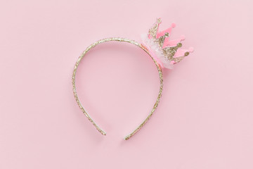 Pink and golden glitter princess crown headband for girls on candy pink background. Festive...