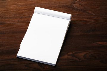 Notepad with red pencil on a brown wooden table background, for education, write goals and deeds