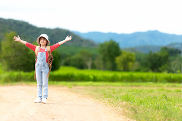 Fototapeta premium Asian girl children raise arms and standing see the outdoors, adventure and tourism for destination and leisure trips with mountain for education and relax in nature park.Â&nbsp; Travel vacations 