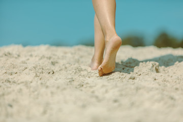 woman legs walking by sand beach summer time