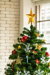Christmas tree decorated in the living room to prepare for the new year. Decorate the living room and christmas tree with a box of red balls, golden balls, golden bells, snow stars, socks.