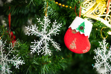 Christmas tree decorated in the living room to prepare for the new year. Decorate the living room and christmas tree with a box of red balls, golden balls, golden bells, snow stars, socks.