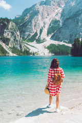 woman standing at the lake beach in mountains sunny summer day