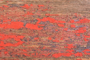 Old wooden background with cracked red paint and dirty textured surface. Old grunge wood backdrop with aged peeling red paint. Vintage rustic background. Ancient colored timber surface 