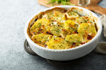 Homemade potato gratin with bacon and herbs