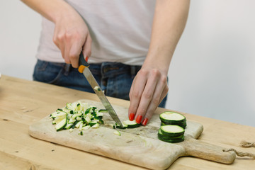 Young Women Cutting Chopping Courgette Zucchini , Vegetables in the kitchen on Cutting Board