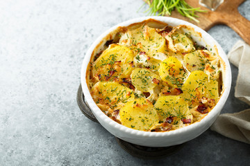Homemade potato gratin with bacon and herbs