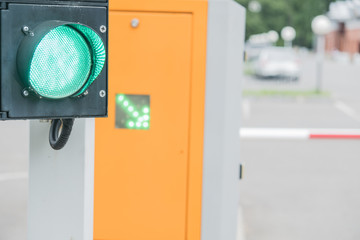 Automatic barrier in the parking lot. Resolving, green light semaphore. Green arrow. Summer, cloudy...