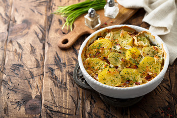 Homemade potato gratin with bacon and herbs