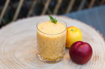 Transparent Glass of Fresh Apple and Nectarine Shake Smoothie Cocktail. It Photographed On a Wooden Plate Background. Photo For a Menu.