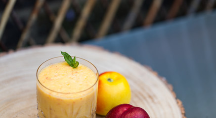 Antioxidant Cocktail of Freshly Squeezed Juice of Nectarine and Apple. Decorated With Green Mint Leaf. Background With Copy Space. Powering Up With a Smoothie Glass. Still life.