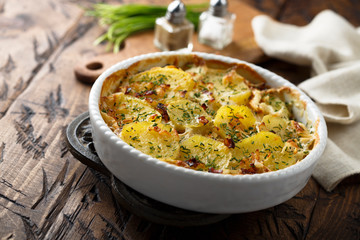Homemade potato gratin with bacon and herbs