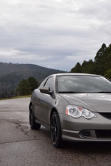 Fototapeta na wymiar Grey sports car on the road with mountain background
