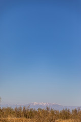 Landscape shot with far snowy mountain with clear sky