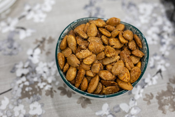 Toasted almonds on a bowl on a table with floral black and white decoration